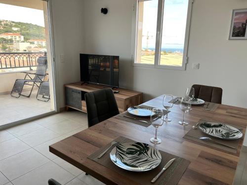 une salle à manger avec une table et une vue sur l'océan dans l'établissement Grand T2 résidence de standing, à LʼÎle-Rousse