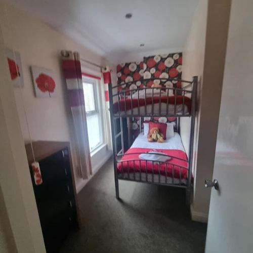a bedroom with a bunk bed with a red blanket at The Fawley Guest house in Shanklin