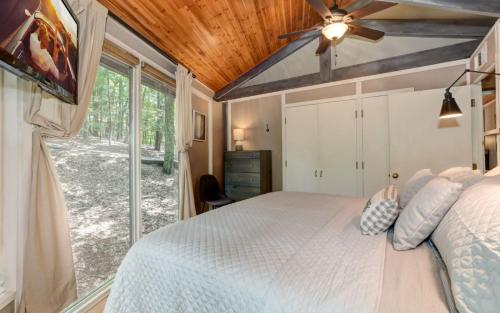 a bedroom with a bed and a large window at Treetopper Hideaway - A Relaxing Chic Bungalow in Marblehill