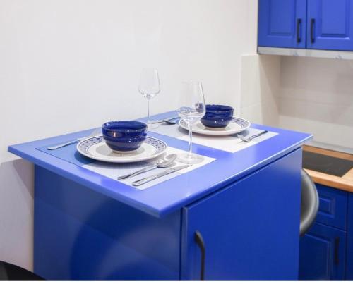 地拉那的住宿－Keli’s apartment，蓝色的柜台,上面有两盘盘,酒杯