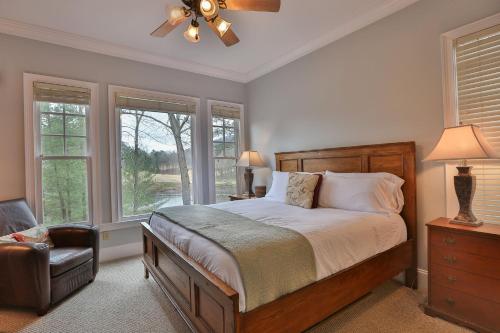 1 dormitorio con 1 cama, 1 silla y ventanas en Lakes Edge Lodge - Water Views Community Golf en Marblehill