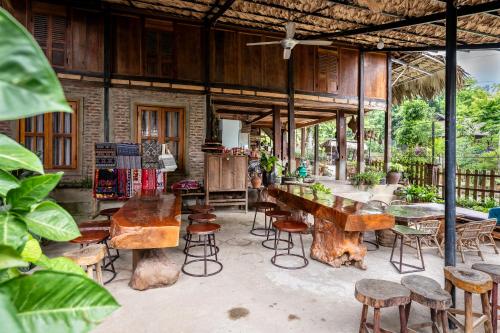 Habitación con mesas de madera, sillas y plantas. en Lim's house en Mai Chau