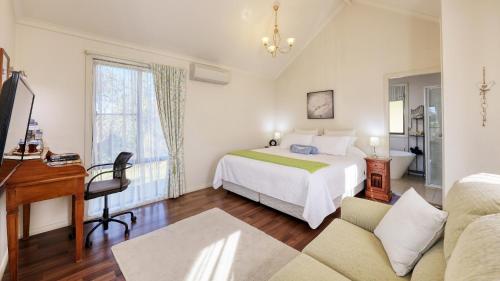 a bedroom with a bed and a desk in a room at Grace Cottages in Uralla