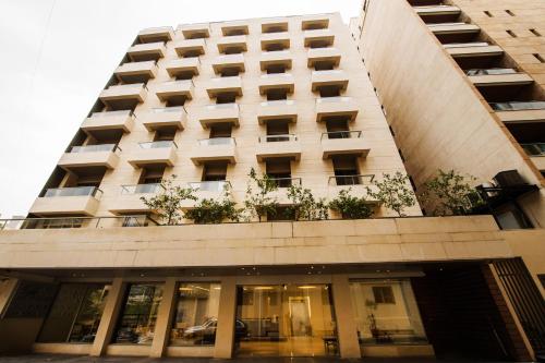 een hoog gebouw met ramen en planten erop bij The Parisian Hotel in Beiroet