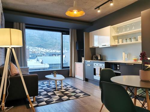 uma cozinha e sala de estar com mesa e cadeiras em Modern apartment with balcony em Cidade do Cabo