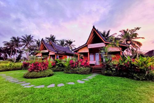 a house with a green lawn in front of it at Mathura Ubud in Ubud