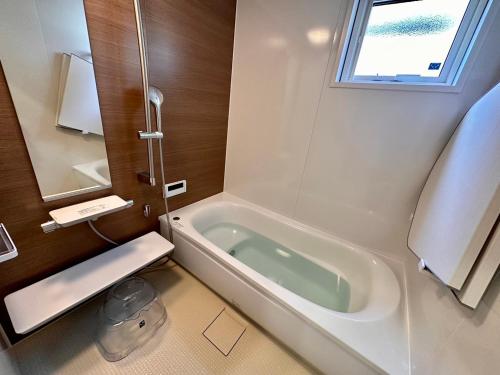 a bathroom with a bath tub and a sink at THE LIVIDA 軽井沢west コナラテラス in Karuizawa