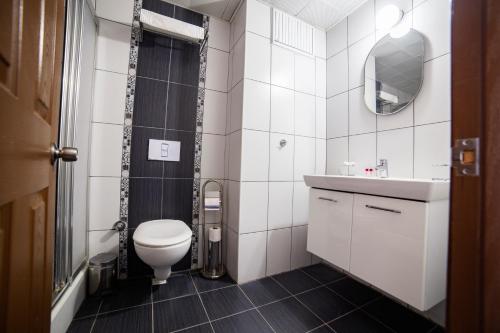 La salle de bains est pourvue de toilettes, d'un lavabo et d'un miroir. dans l'établissement Bartu Otel, à Çeşme