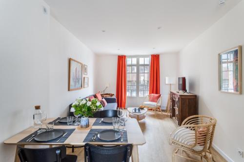 un salon avec une table avec des fleurs dessus dans l'établissement Résidence Hostin'Malo - Au cœur de Saint Malo, à Saint-Malo