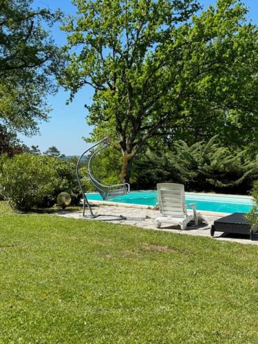 une piscine avec un toboggan au milieu d'un parc dans l'établissement Gîte Tennis du domaine de Mary, à Brive-la-Gaillarde
