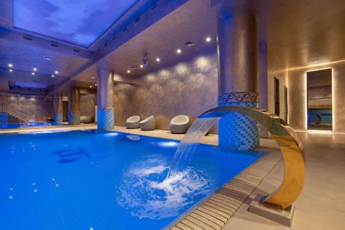uma piscina com cascata num quarto de hotel em VISIONAPARTMENTS Bucharest Calea Victoriei em Bucareste