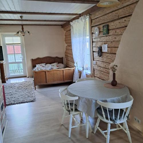a room with a table and chairs and a bed at Tagalahe Apartment in Haapsalu