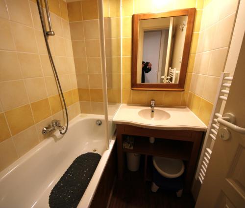 une salle de bain avec un lavabo, une baignoire et un miroir dans l'établissement Au coeur de l'Ariège, à Ax-les-Thermes