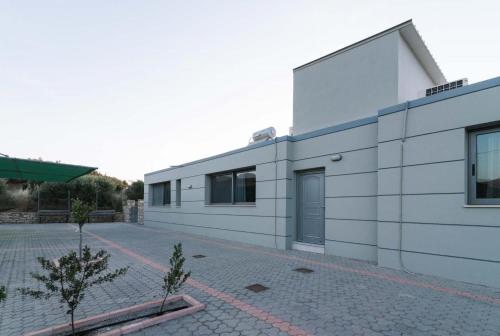 a white building with a courtyard in front of it at Amfithea Villas Petrokefali in Petrokefálion