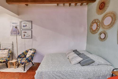 - une chambre avec un lit, une chaise et des miroirs dans l'établissement Charmant studio proche du Vieux Port, à Marseille