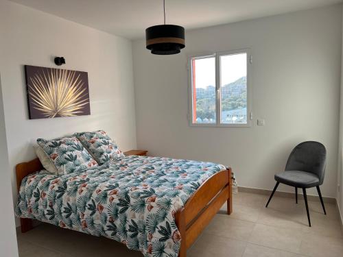 une chambre avec un lit, une chaise et une fenêtre dans l'établissement Grand T2 résidence de standing, à LʼÎle-Rousse