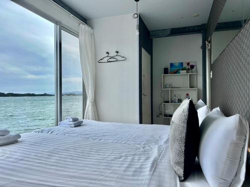 a bedroom with a large bed with a large window at Nel Beach in Nago