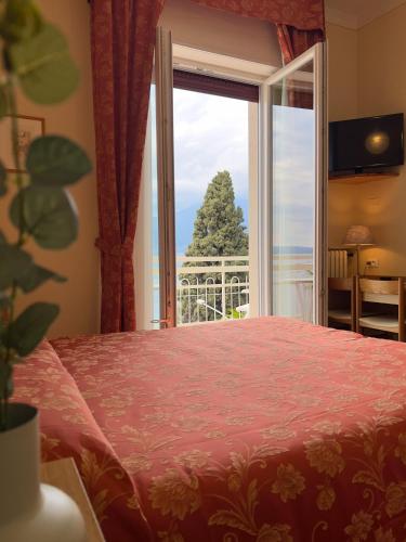 a bedroom with a bed and a large window at Hotel Benacus Torri del Benaco in Torri del Benaco