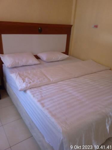 una cama con dos almohadas encima en Thenewgoldensunrise, en Tuk Tuk