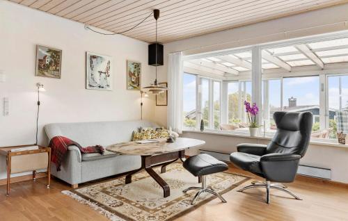 a living room with a couch and a table and chairs at Amazing Home In Augustenborg in Augustenborg