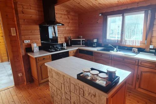 - une cuisine avec un îlot dans une cabane en rondins dans l'établissement Chalet du Parc Montréal, à Neuville-sur-Vanne