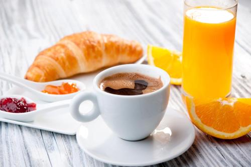 une tasse de café et une assiette de jus d'orange dans l'établissement Résidence Montana Clamart, à Clamart