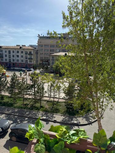 a view of a parking lot with a tree and buildings at Old City Guesthouse and Tour Ulaanbaatar Hostel in Ulaanbaatar