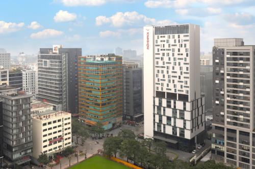 eine Luftansicht einer Stadt mit hohen Gebäuden in der Unterkunft Mövenpick Living West Hanoi in Hanoi