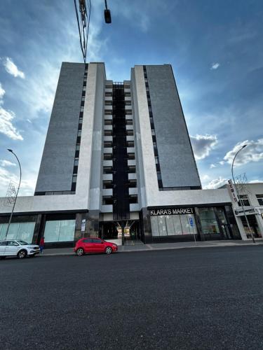 un bâtiment avec une voiture rouge garée devant dans l'établissement Windhoek Kalahari Haven, à Windhoek