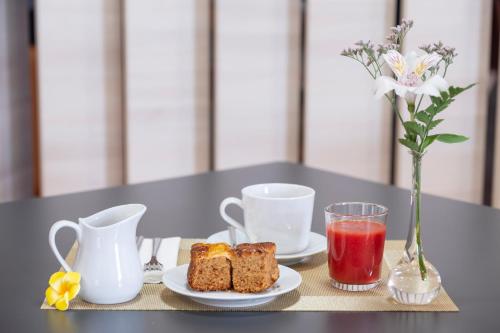a table with two plates of food and two cups and a drink at Hotel CampusPHI in Acebo