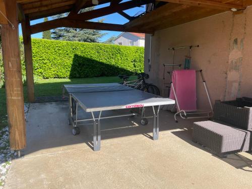 une table de ping-pong installée dans un patio dans l'établissement Maison privatisée avec piscine et jardin 4 chambres, à Sain-Bel