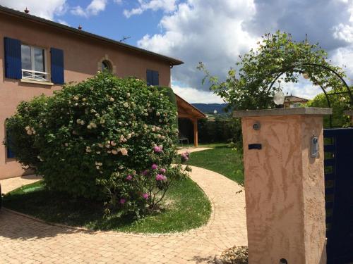 un jardin avec une brousse à côté d'une maison dans l'établissement Maison privatisée avec piscine et jardin 4 chambres, à Sain-Bel