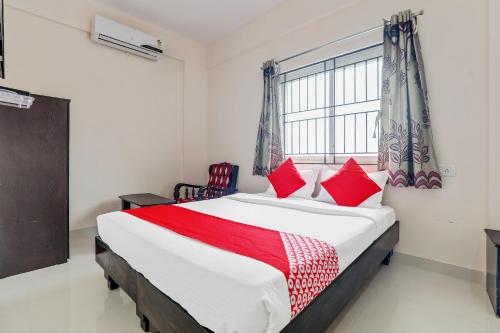 1 dormitorio con 1 cama grande con almohadas rojas en 49996 JJ Comforts en Bangalore