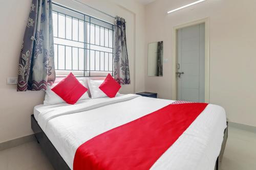 a bedroom with a large bed with red pillows at 49996 JJ Comforts in Bangalore