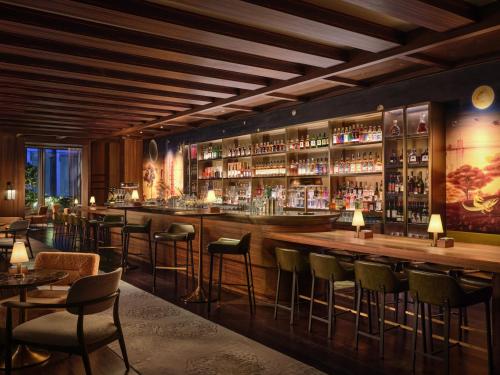 a bar in a restaurant with chairs and tables at Rosewood Guangzhou, enjoy free shuttle bus service between the hotel and the Canton Fair Complex during the Canton Fair in Guangzhou