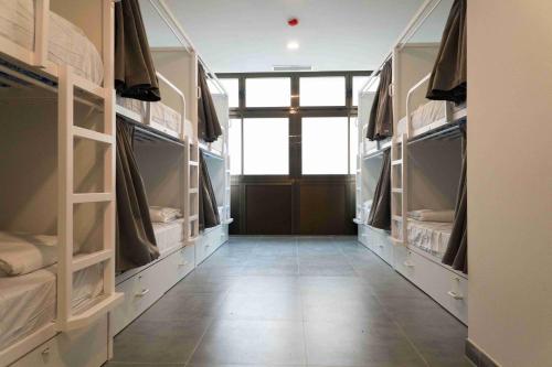 un pasillo con estanterías abiertas en una habitación con puerta en Sea Hostel Barcelona en Barcelona
