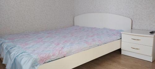 um pequeno quarto com uma cama e uma cómoda em Zem Priedēm em Lapmežciems