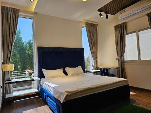 a bedroom with a bed with a large window at (Anushthan Villa) serviced villa for staycation in Ajman 