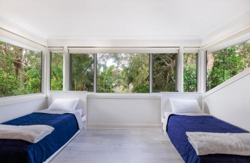 Duas camas num quarto com janelas grandes em Anais Hat Head em Hat Head