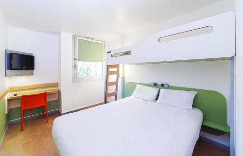 a bedroom with a bed and a desk and a bed at ibis budget Caen Mondeville in Mondeville