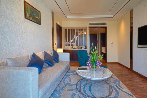 Devanhalli的住宿－班加羅爾泰伊酒店，客厅配有沙发和桌子