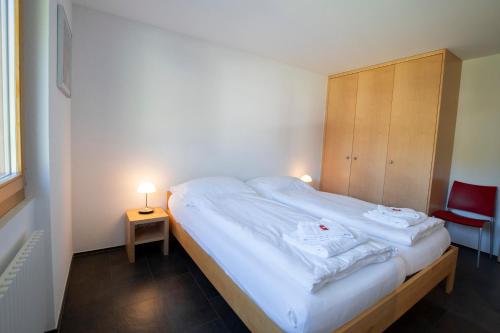 a bedroom with a large bed with two towels on it at Haus Bella Vista in Riederalp