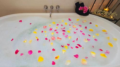 a bath tub filled with lots of pink flowers at Grace Cottages in Uralla