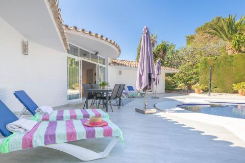 een patio met een bed en een zwembad bij Pool Villa Rancho Domingo family friendly - Happy Rentals in Benalmádena