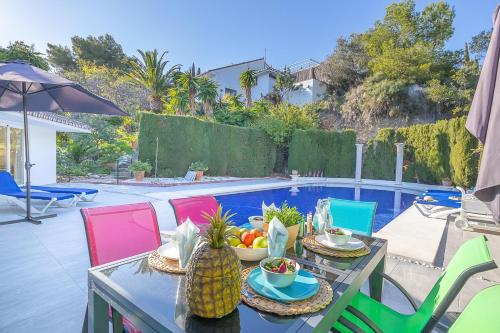 een tafel met fruit erop naast een zwembad bij Pool Villa Rancho Domingo family friendly - Happy Rentals in Benalmádena