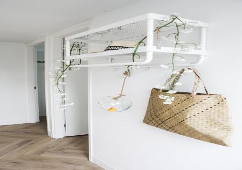 een kamer met een witte plank met een handtas bij Stijlvol ingerichte (4 pers.) bungalow in Baarland in Baarland