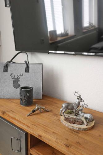 a wooden table with a statue of a deer on it at Ferienhaus im Sollingstyle in Dassel