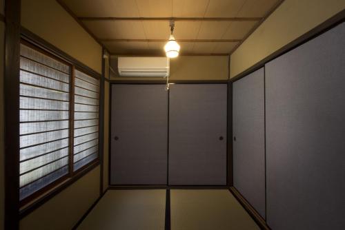 um quarto vazio com portas brancas e uma luz em Gion House em Quioto