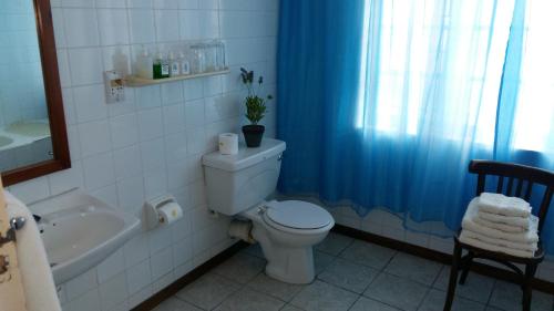 a bathroom with a toilet and a tub and a sink at Albertinia Hotel in Albertinia