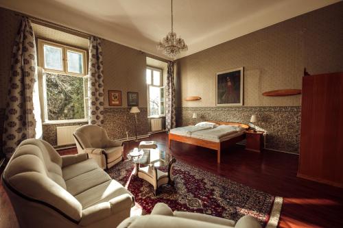 a bedroom with a bed and a living room at Hotel Kaštieľ Mojmírovce in Mojmírovce